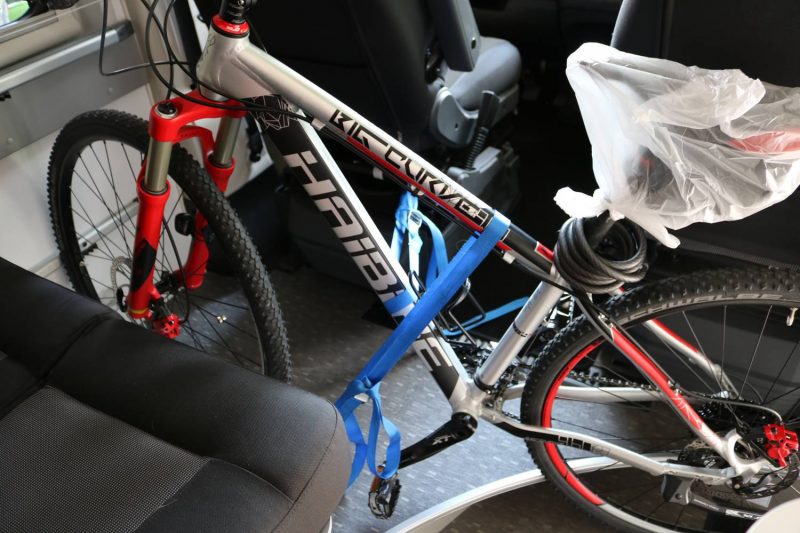 Mit zwei Spanngurten, einen an der Zurrtes, einen an der Stange des Fahrersitzes befestigt kann man das Fahrrad perfekt fixieren.