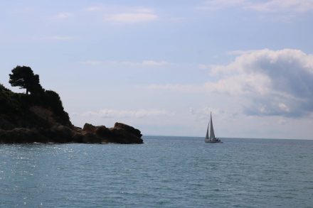 Aus der Bucht von Ulcinj segelt ein Boot aufs Meer hinaus.