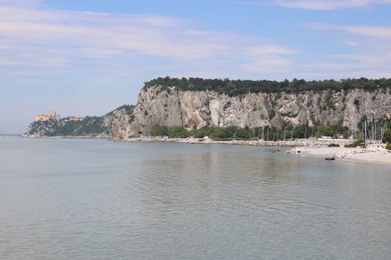 Das Schloss von Duino, der Rilke Weg oben auf dem Felsplateau und darunter der Strand von Sistiana.