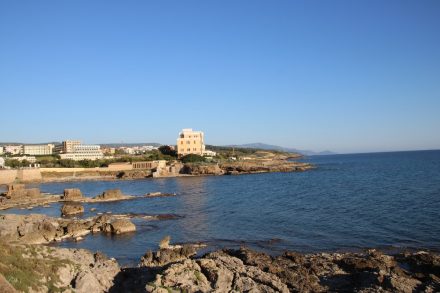 Die kleinen Stadtstrände von Alghero mit roten Felsen und tiefblauem Meer