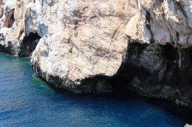 Türkisfarbenes Wasser und die steilen Kalksteinfelsen des Capo Caccia